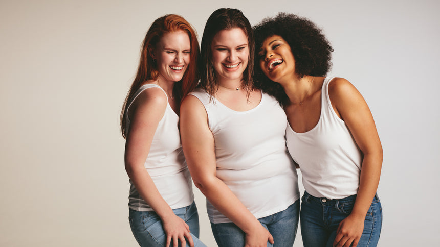 Diverse group of women laughing together on white background. Females in casuals looking happy together.